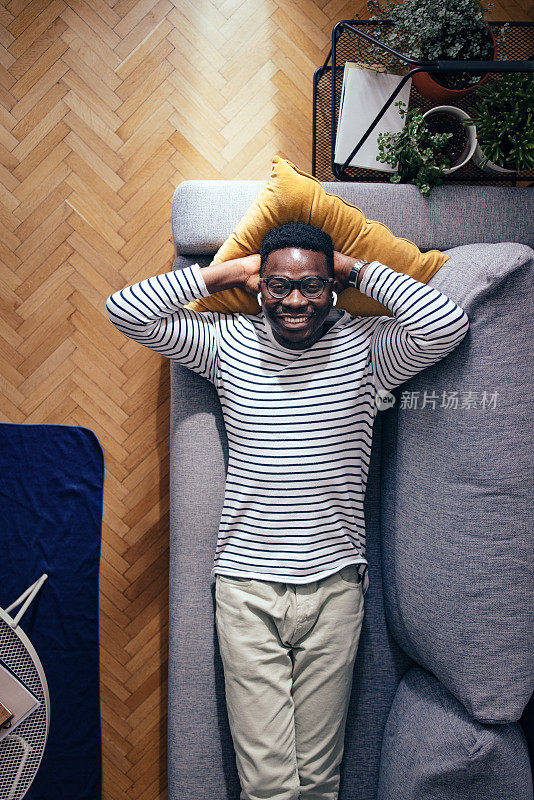 Top View Of Happy BusinessmanÂ Lying On A Sofa In The Living Room And Looking At Camera